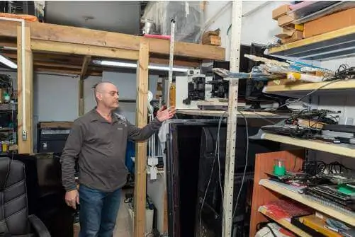 יצחק מצביע על מיקרוסקופים תעשייתיים